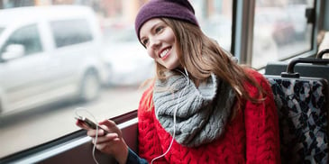 Young woman listening to headphones and smiling